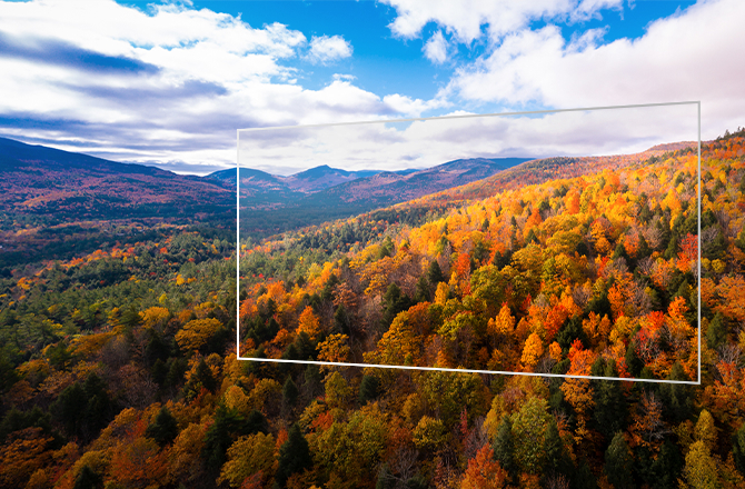 The image shows a transparent display floating above a mountainous landscape of colorful autumn forests and blue skies, with a high-definition screen with three times the brightness thanks to tandem OLED technology.